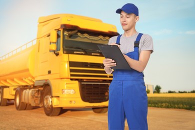 Image of Car service worker with clipboard and truck outdoors