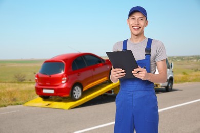 Image of Car service worker with clipboard near red auto and tow truck outdoors