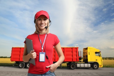 Image of Car service worker with headset and clipboard against truck outdoors. Client support
