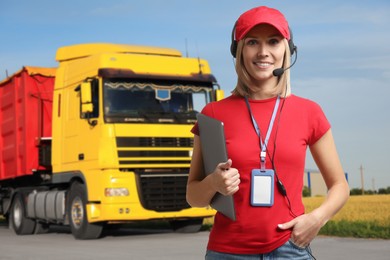 Image of Car service worker with headset and clipboard against truck outdoors. Client support