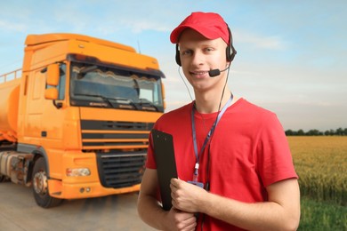 Image of Car service worker with headset and clipboard against truck outdoors. Client support