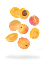 Image of Fresh juicy apricots falling against white background