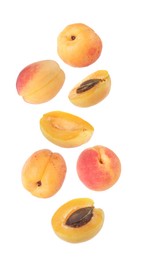 Image of Fresh juicy apricots falling against white background
