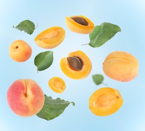 Image of Fresh juicy apricots swirling in air against light blue background
