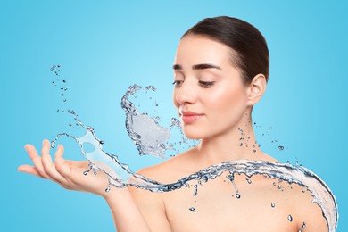 Image of Woman with smooth skin and water splash against light blue background