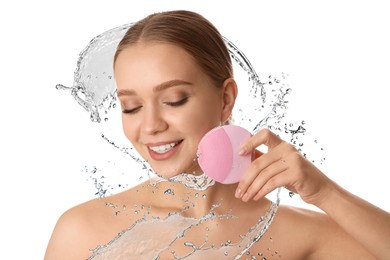 Image of Young woman washing face with cleansing brush and water splash against white background