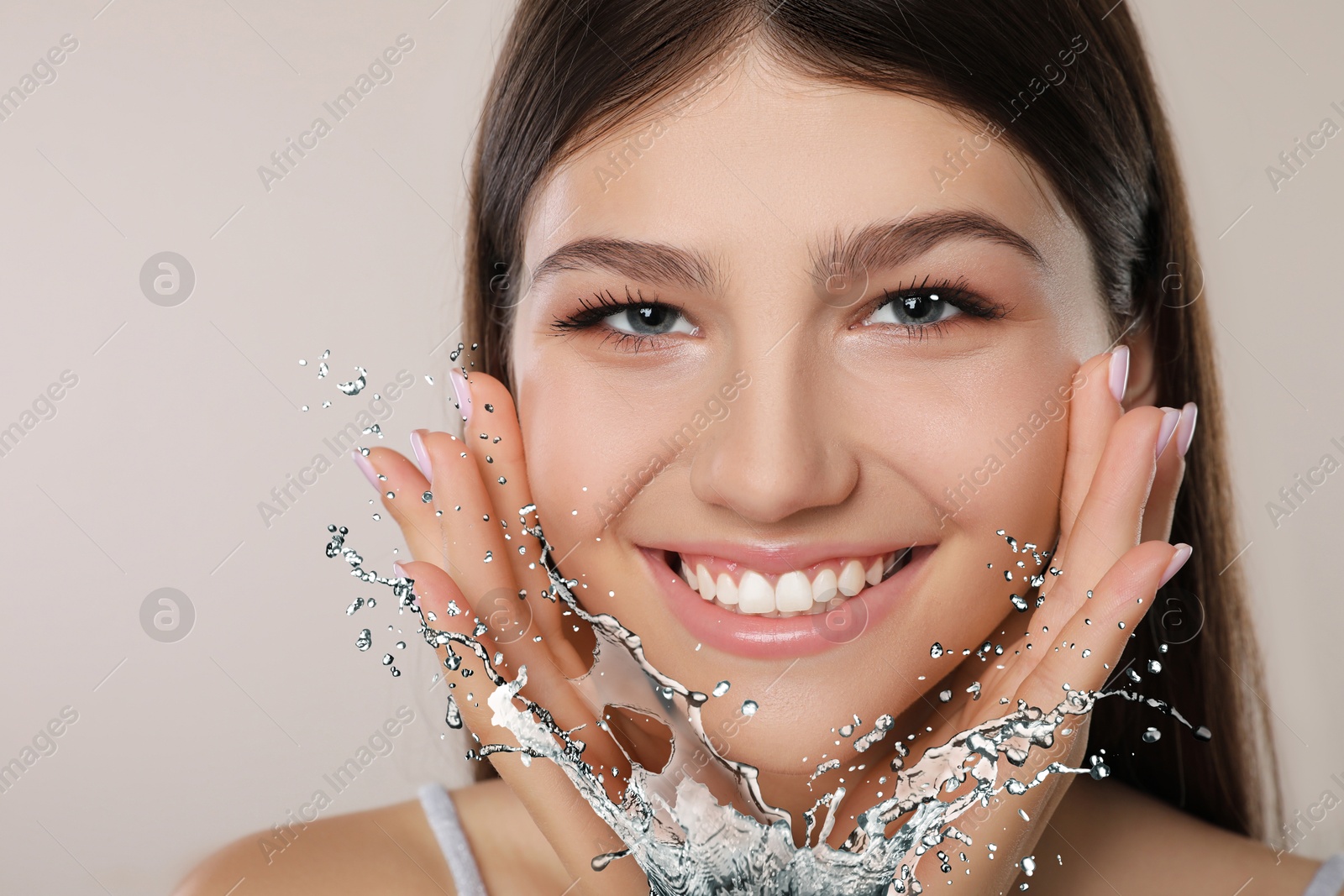 Young girl with smooth skin and water splash against light grey background Image of Young girl with smooth skin and water splash against light grey background