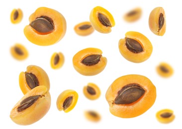 Image of Fresh juicy apricot halves in air against white background