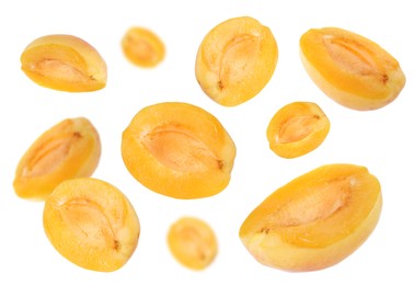 Image of Fresh juicy apricot halves in air against white background