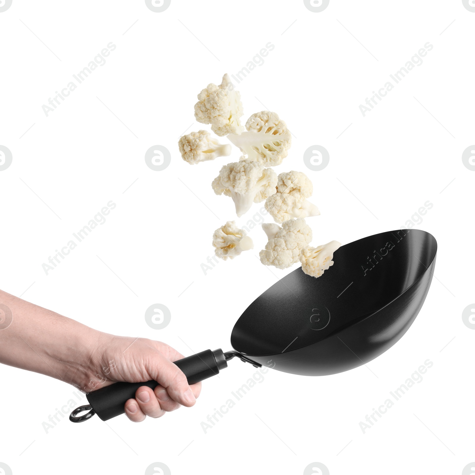 Man tossing cauliflower while frying it in wok against white background, closeup Image of Man tossing cauliflower while frying it in wok against white background, closeup