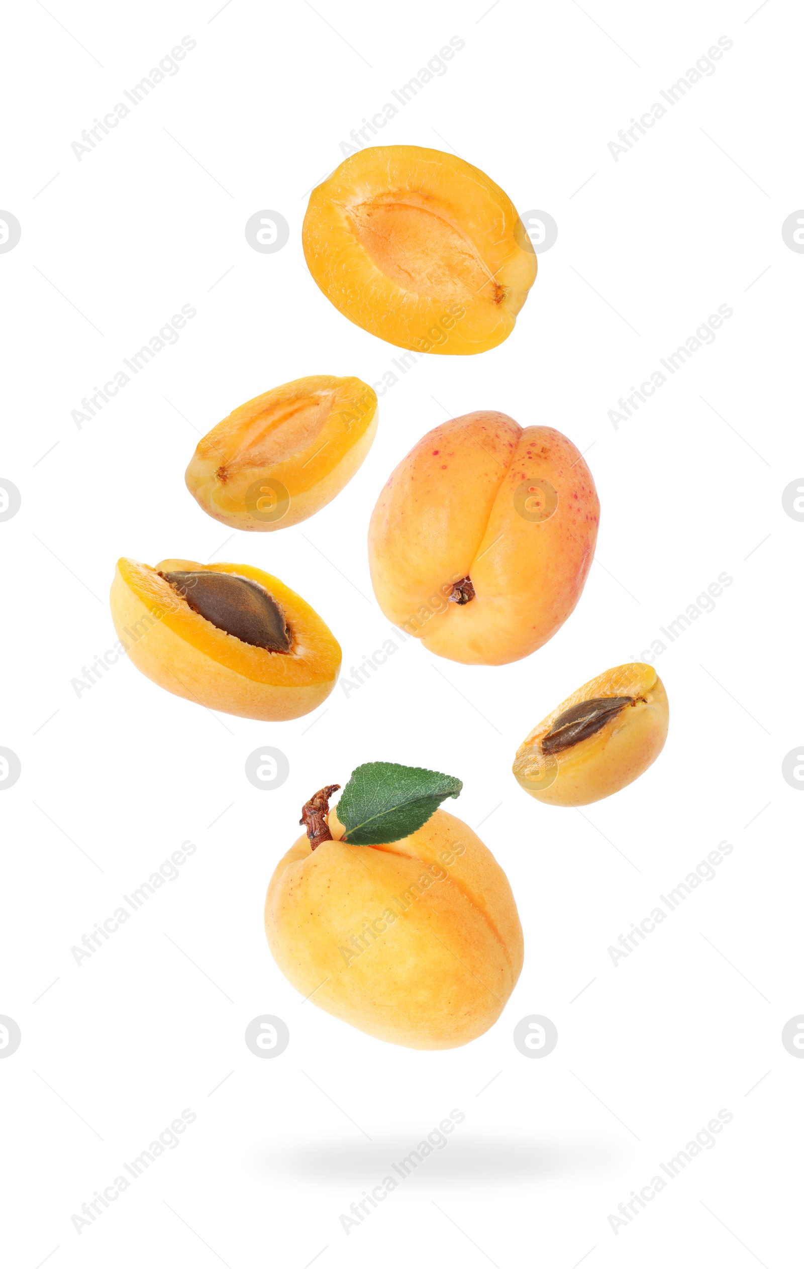 Image of Fresh juicy apricots falling against white background