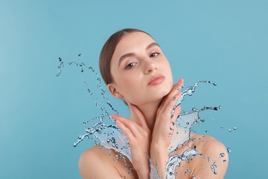 Image of Woman with smooth skin and water splash against light blue background