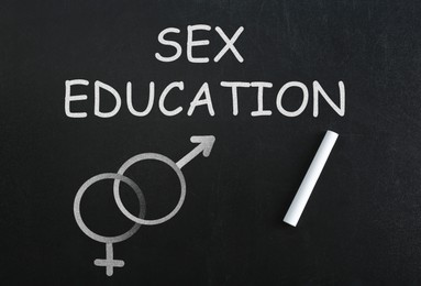 Image of Sex Education inscription, female and male gender signs on black chalkboard