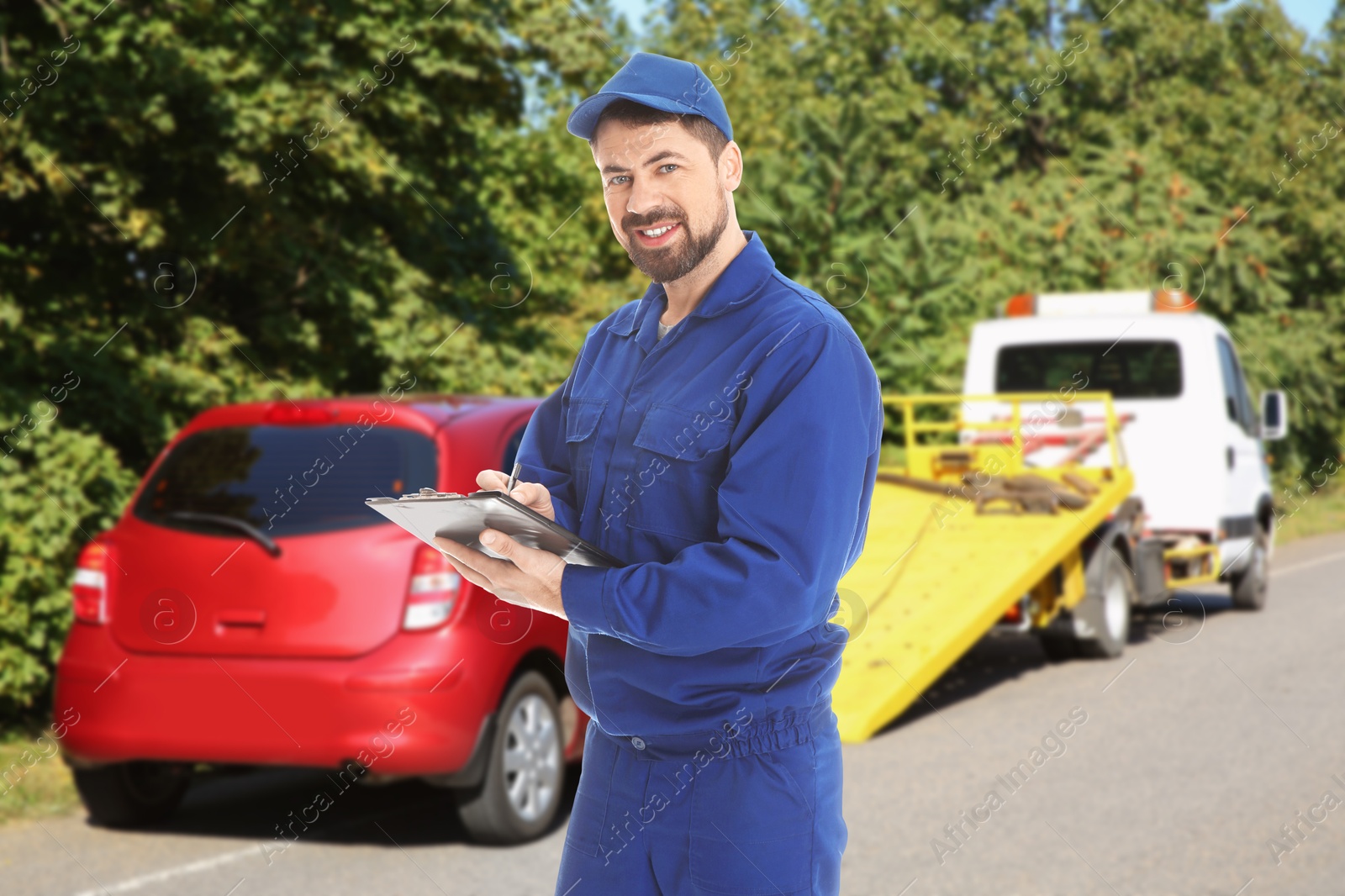 Car service worker with clipboard near red auto and tow truck outdoors Image of Car service worker with clipboard near red auto and tow truck outdoors
