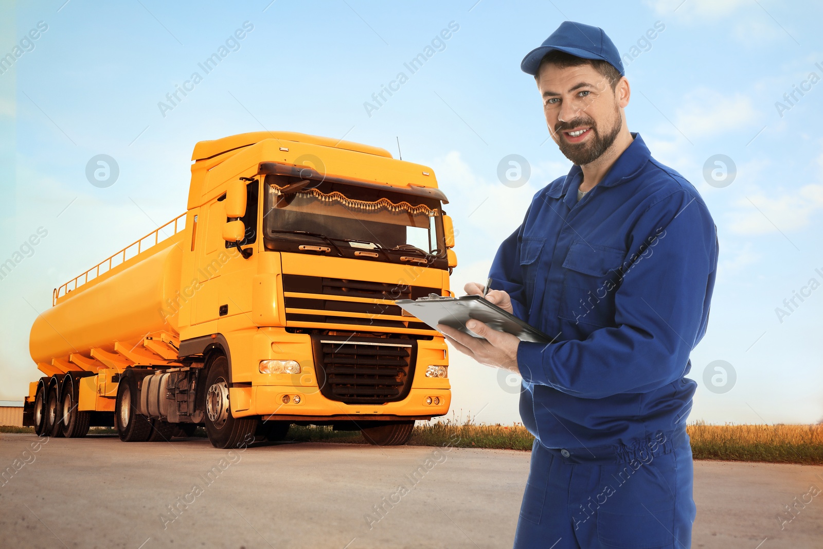 Image of Car service worker with clipboard and truck outdoors