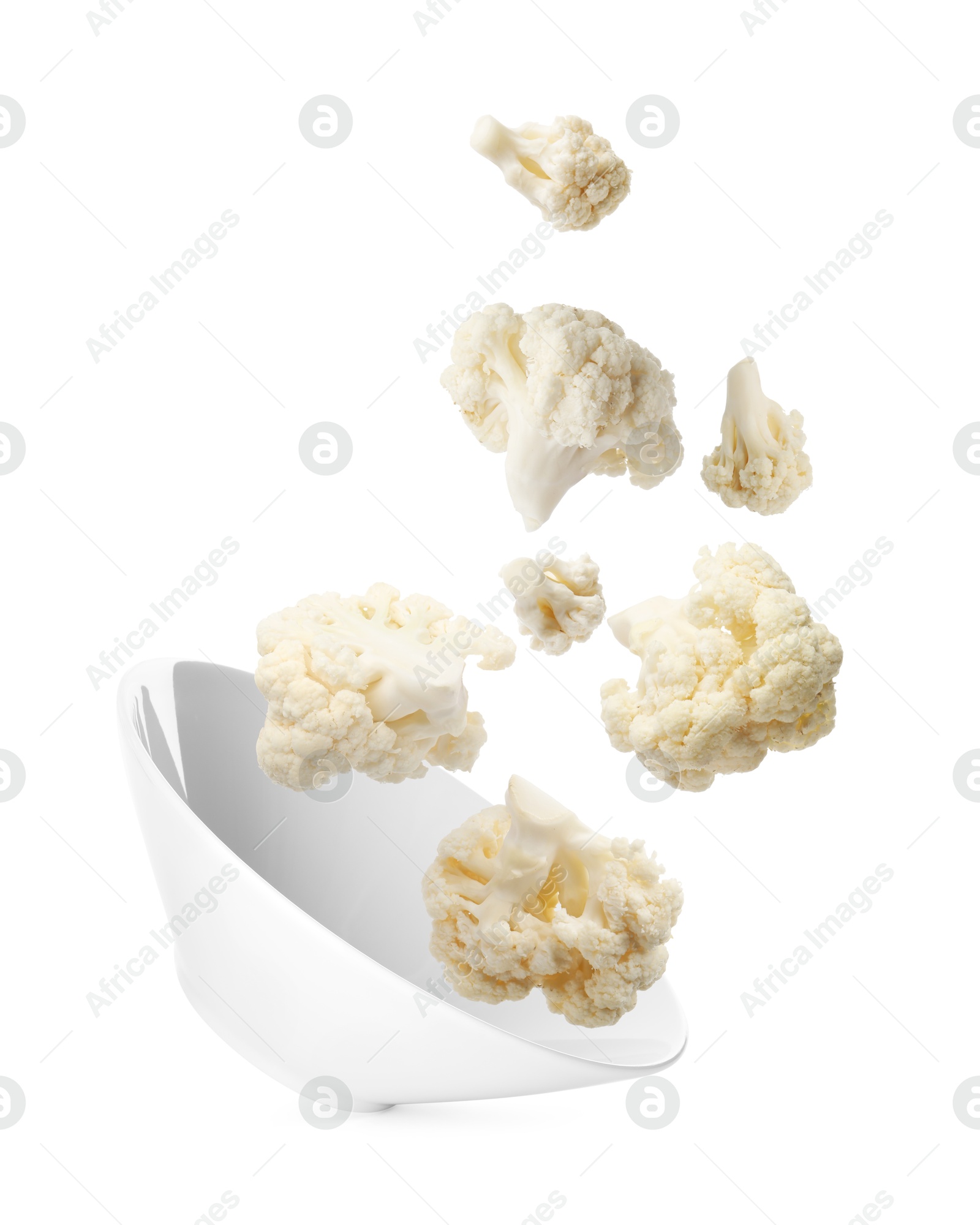 Image of Cauliflower florets and bowl in air against white background