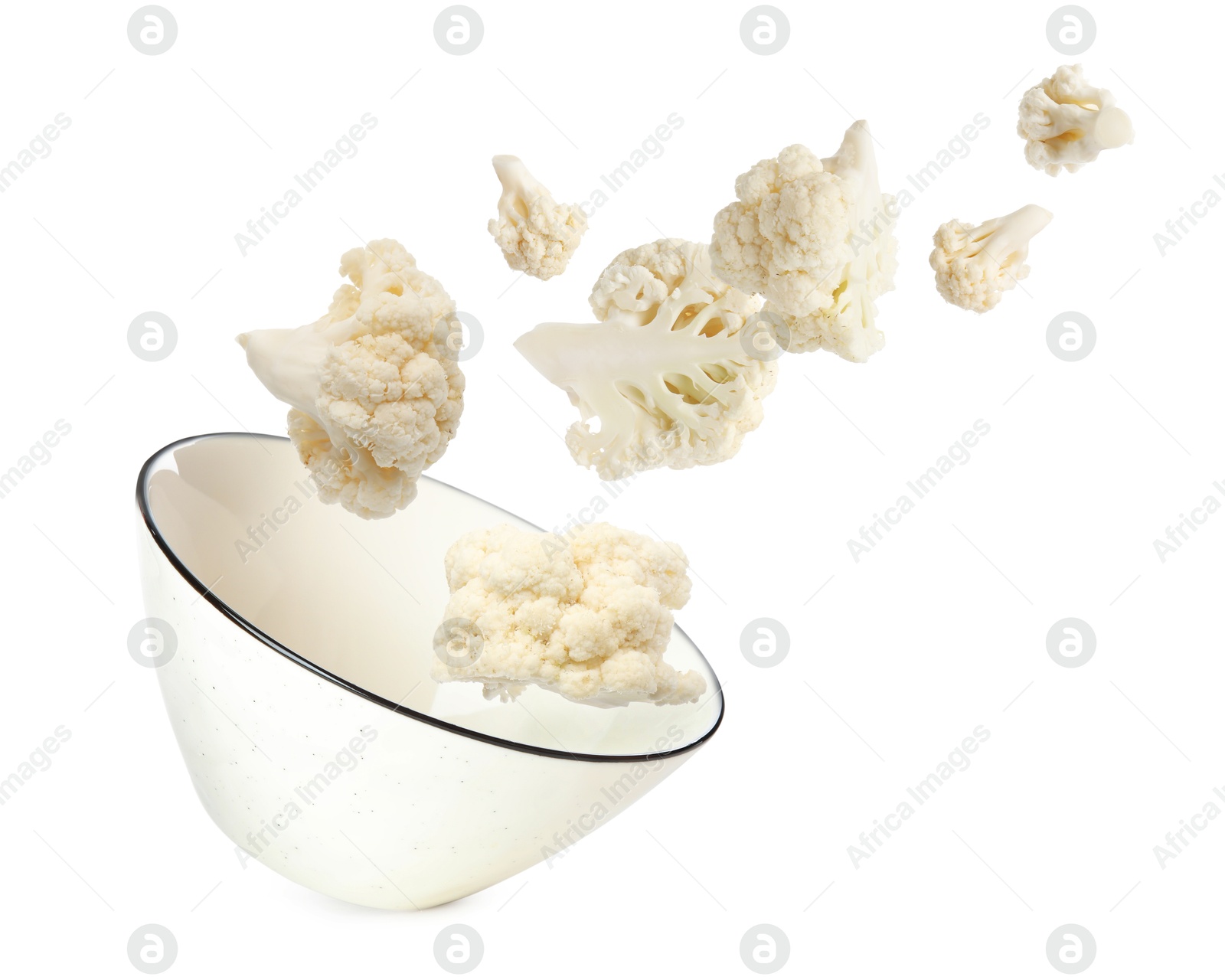 Image of Cauliflower florets and bowl in air against white background