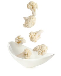 Image of Cauliflower florets falling into bowl against white background