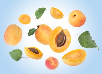 Image of Fresh juicy apricots swirling in air against light blue background