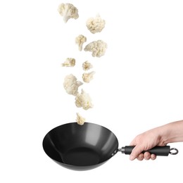 Image of Man tossing cauliflower while frying it in wok against white background, closeup