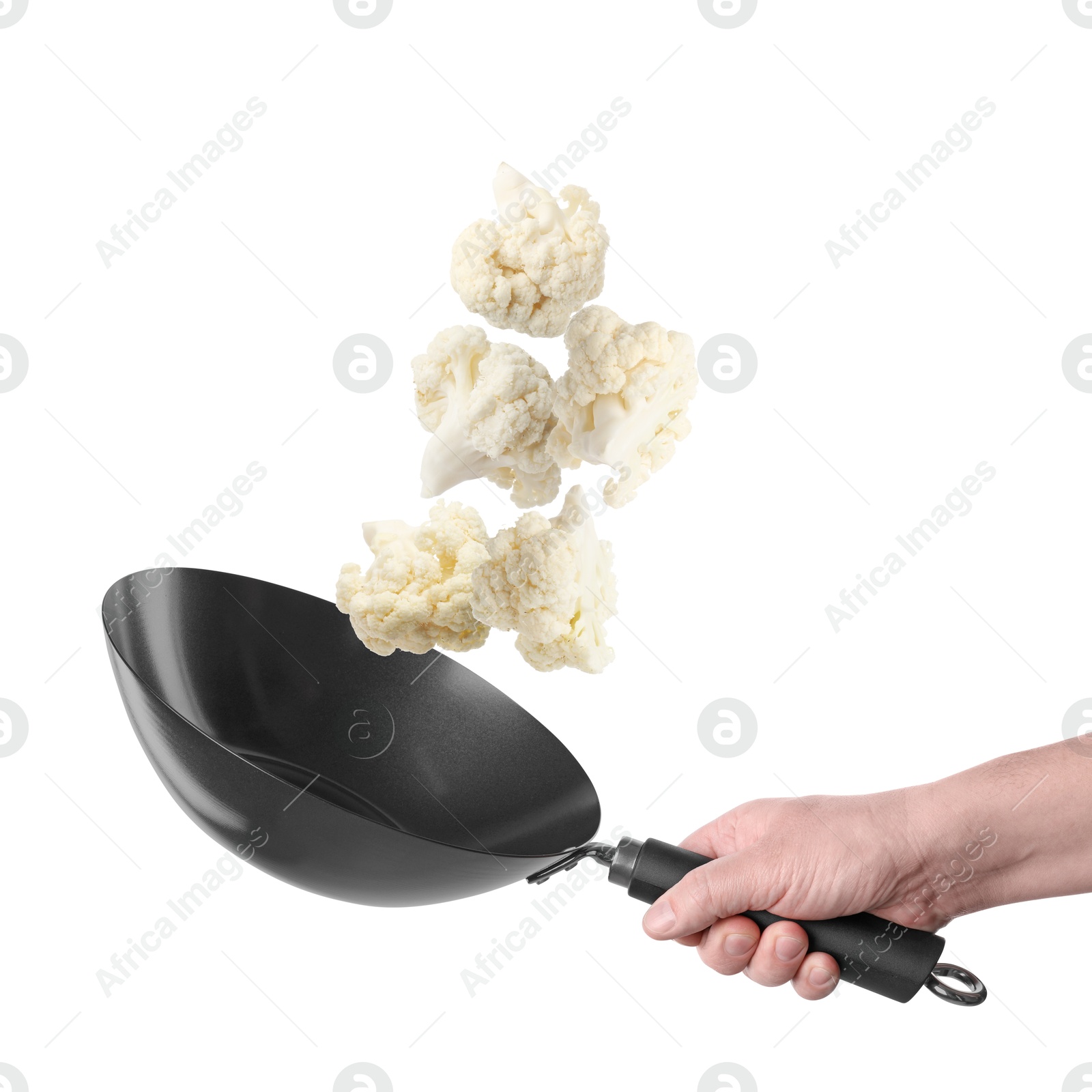 Man tossing cauliflower while frying it in wok against white background, closeup Image of Man tossing cauliflower while frying it in wok against white background, closeup