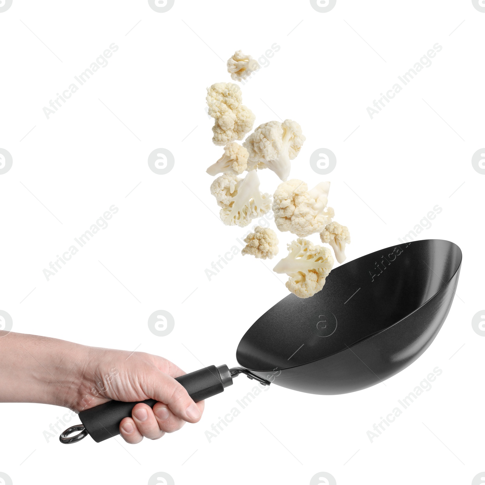 Man tossing cauliflower while frying it in wok against white background, closeup Image of Man tossing cauliflower while frying it in wok against white background, closeup