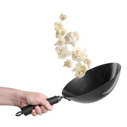Image of Man tossing cauliflower while frying it in wok against white background, closeup