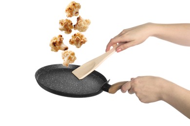 Image of Woman tossing cauliflower while frying it in wok against white background, closeup