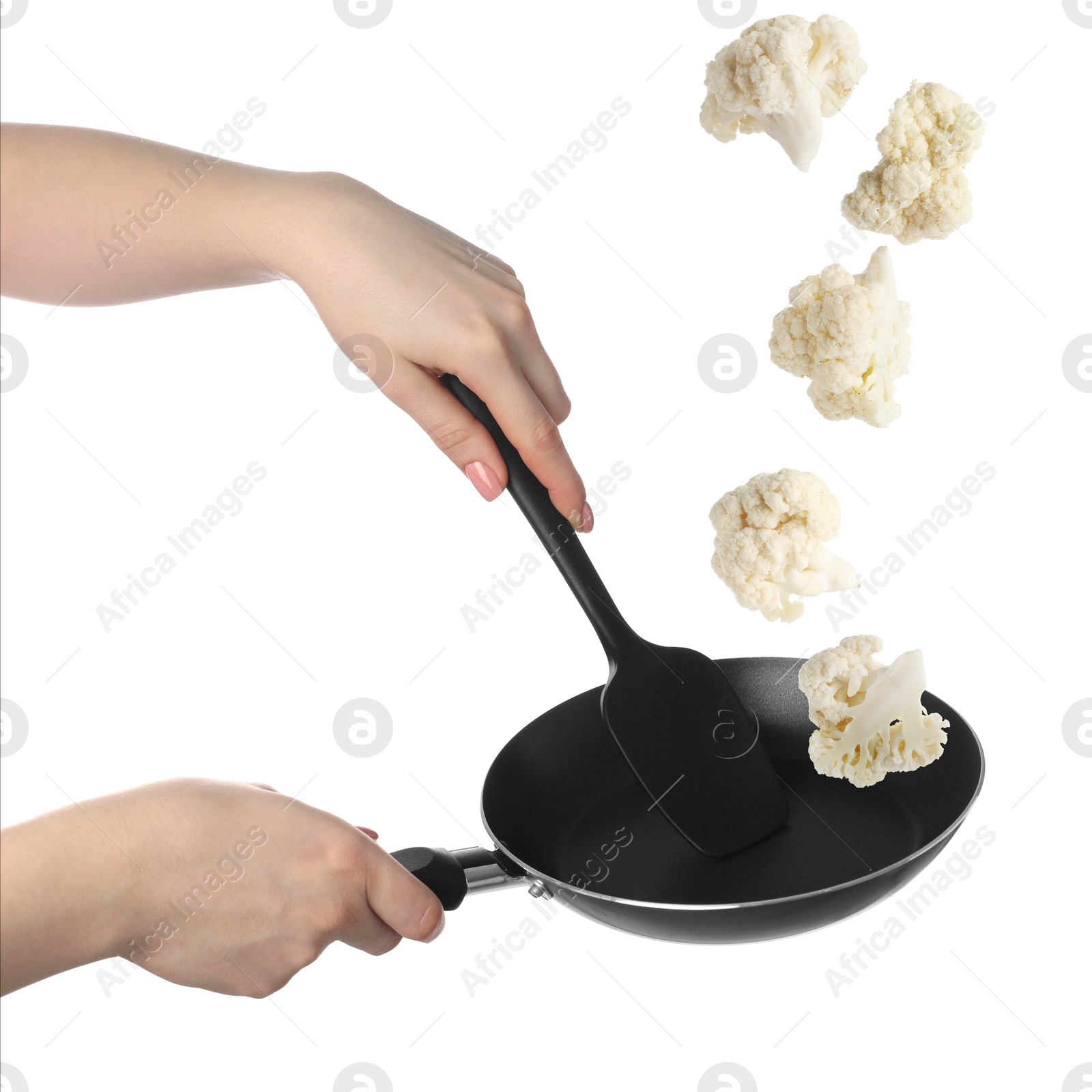 Woman tossing cauliflower while frying it in wok against white background, closeup Image of Woman tossing cauliflower while frying it in wok against white background, closeup
