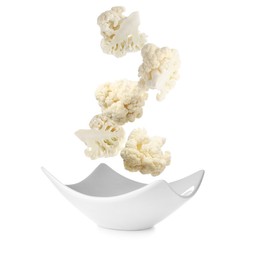 Image of Cauliflower florets falling into bowl against white background