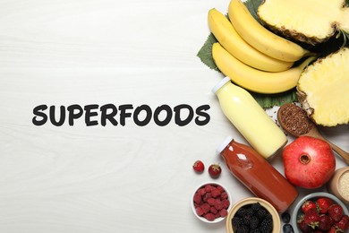 Image of Superfoods. Healthy smoothies in glass bottles and ingredients on table, top view