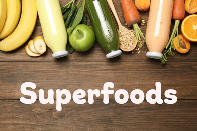 Image of Superfoods. Healthy smoothies in glass bottles and ingredients on wooden table, top view