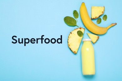 Image of Superfood. Healthy smoothie in glass bottle and ingredients on light blue background, top view