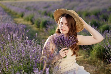 Photo of Beautiful young woman with lavender flowers in field