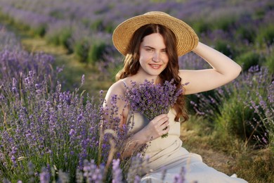 Photo of Beautiful young woman with lavender flowers in field