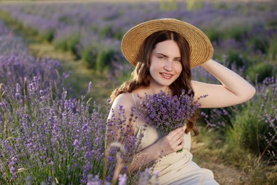 Photo of Beautiful young woman with lavender flowers in field