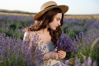 Photo of Beautiful young woman with lavender flowers in field