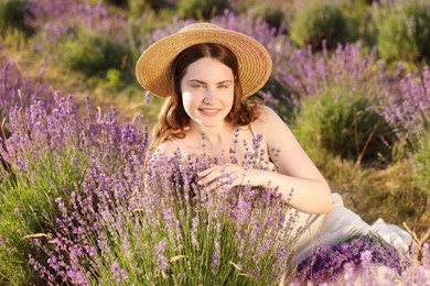 Photo of Beautiful young woman among lavender flowers in field