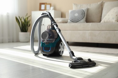 Photo of One vacuum cleaner on floor indoors. Household appliance