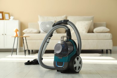 Photo of One vacuum cleaner on floor indoors. Household appliance