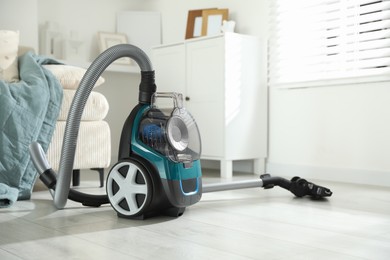 Photo of One vacuum cleaner on floor indoors. Household appliance