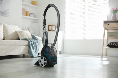 Photo of One vacuum cleaner on floor indoors. Household appliance