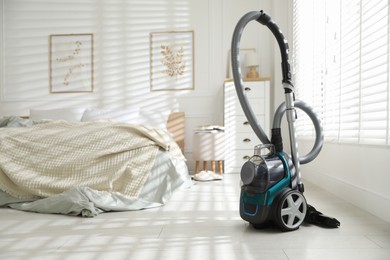 Photo of One vacuum cleaner on floor in bedroom. Household appliance