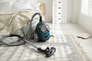 Photo of One vacuum cleaner on floor in bedroom. Household appliance