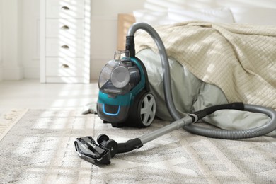 Photo of One vacuum cleaner on floor in bedroom. Household appliance