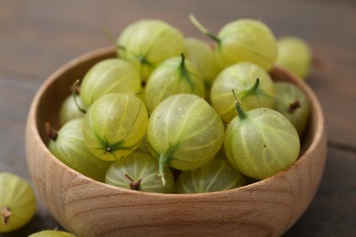 Photo of Fresh green gooseberries in bowl on table, closeup