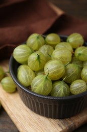Photo of Fresh green gooseberries in bowl on table, closeup