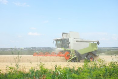 Photo of Modern combine harvester working in wheat field