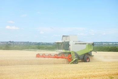 Photo of Modern combine harvester working in wheat field
