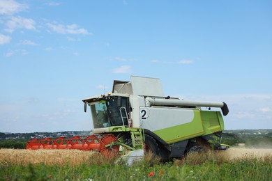 Photo of Modern combine harvester working in wheat field